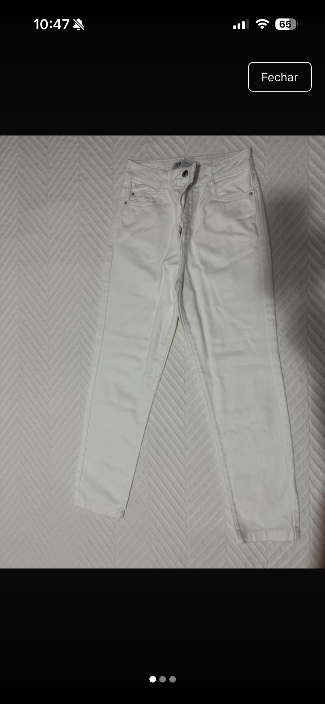 White jeans on a zigzag-textured surface. Text: 10:47, 65, Close, ZARA.