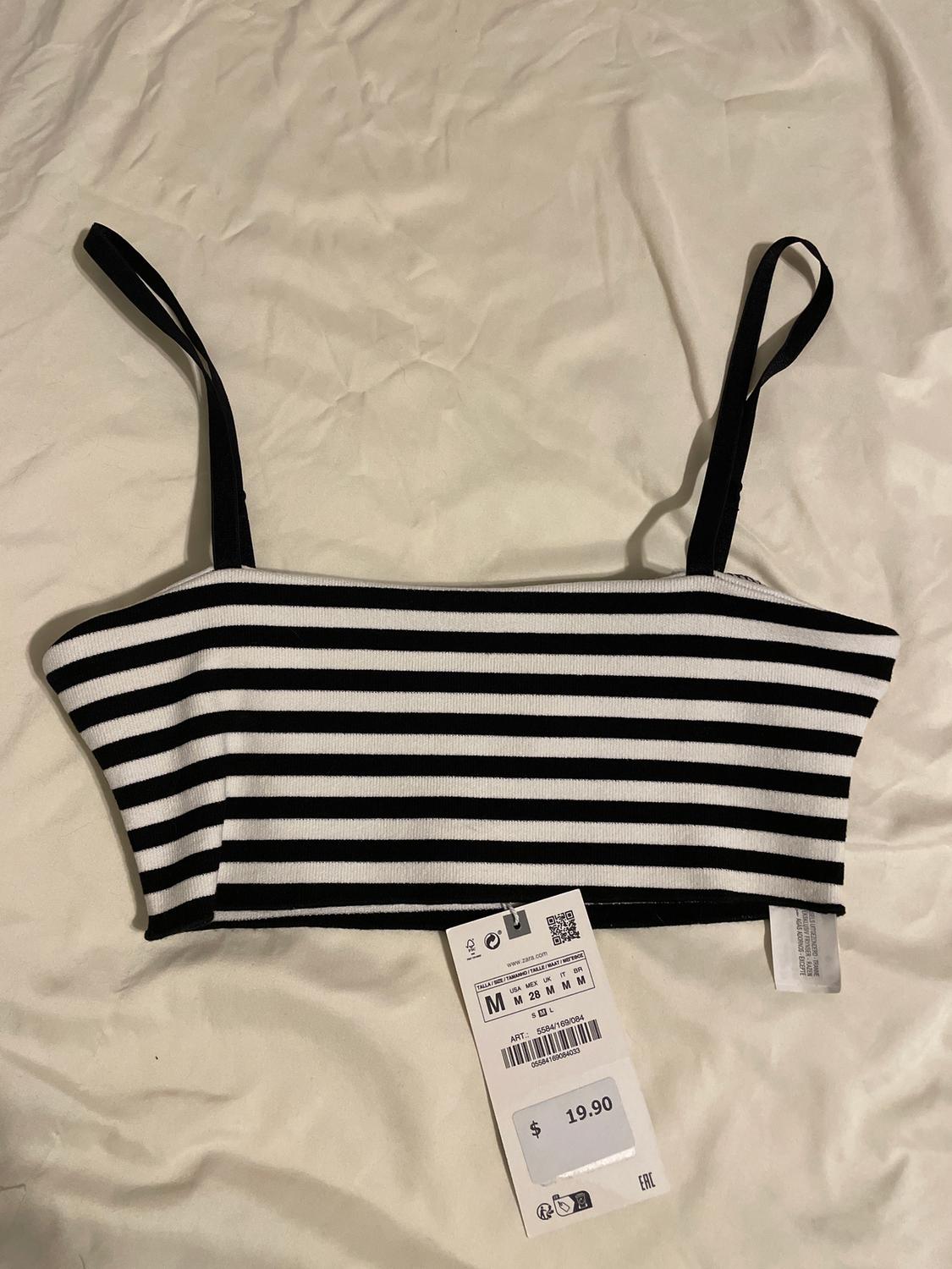 Black and white horizontal striped vest top on white fabric. Label shows size M and price $19.90.