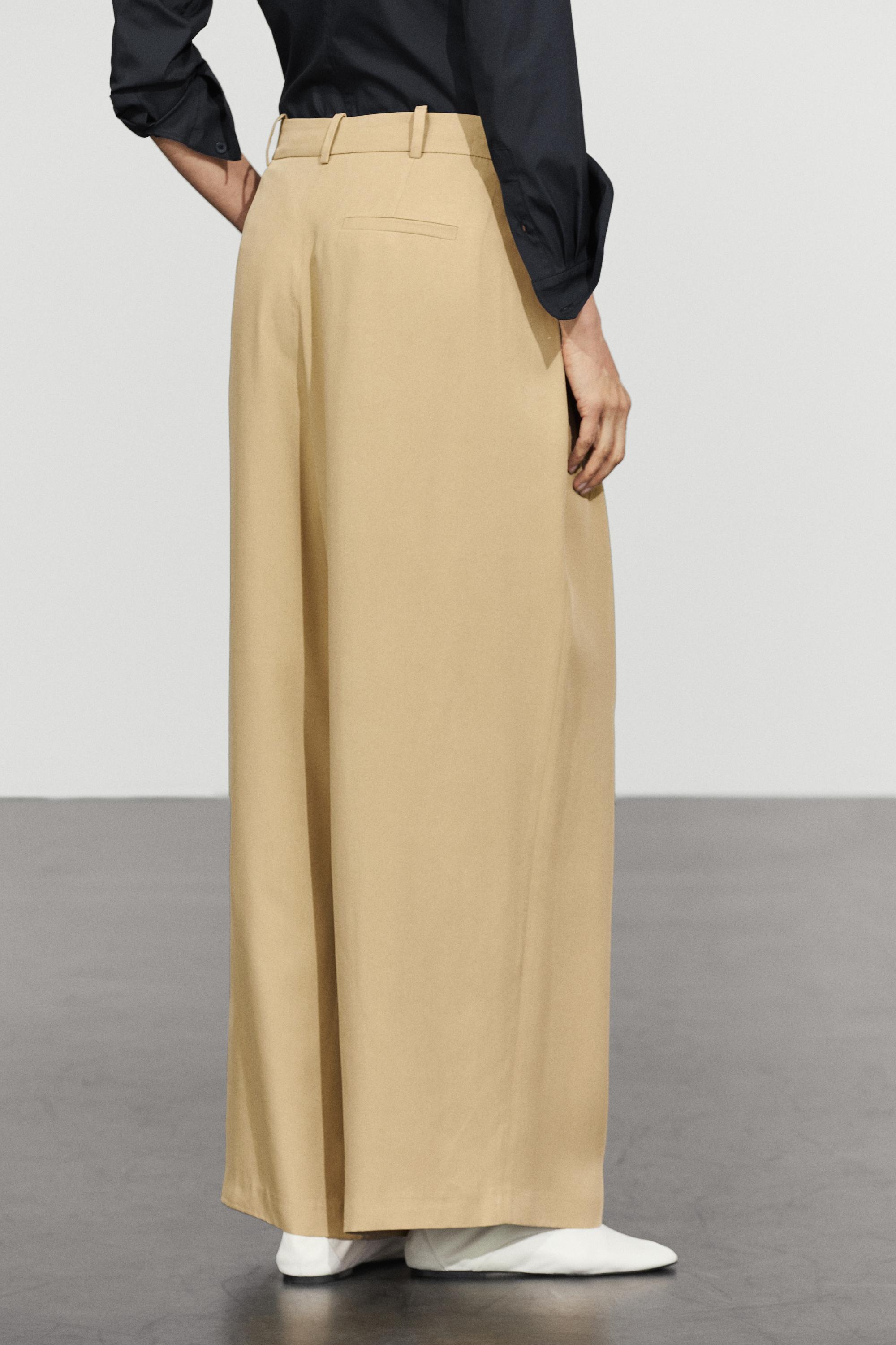 Flowing pleated pants with button detail