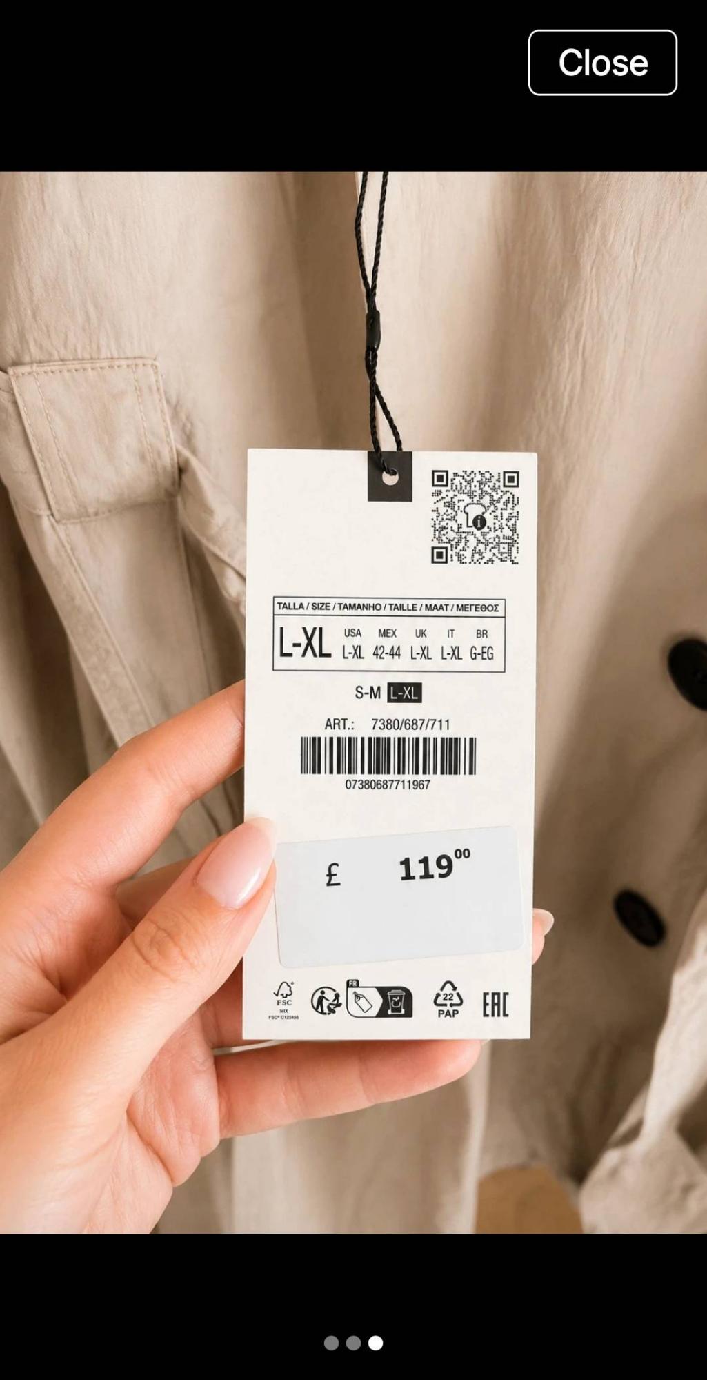 Hand holds beige garment label. Text: Close, SIZE L-XL, ART.: 7380/687/711, 07380687711967, £ 119.00.