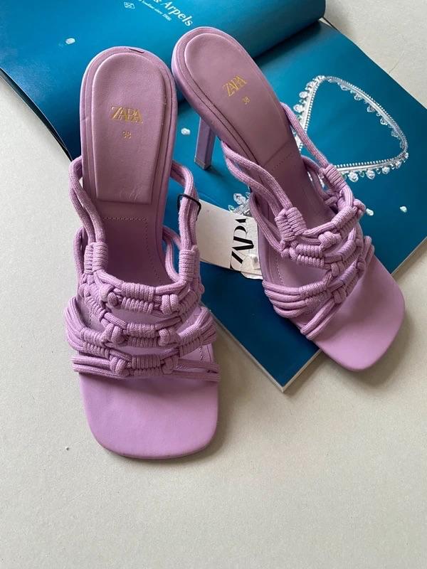 Lilac heeled sandals with a braided design on an open magazine. Visible text: "ZARA 38" on the insole.