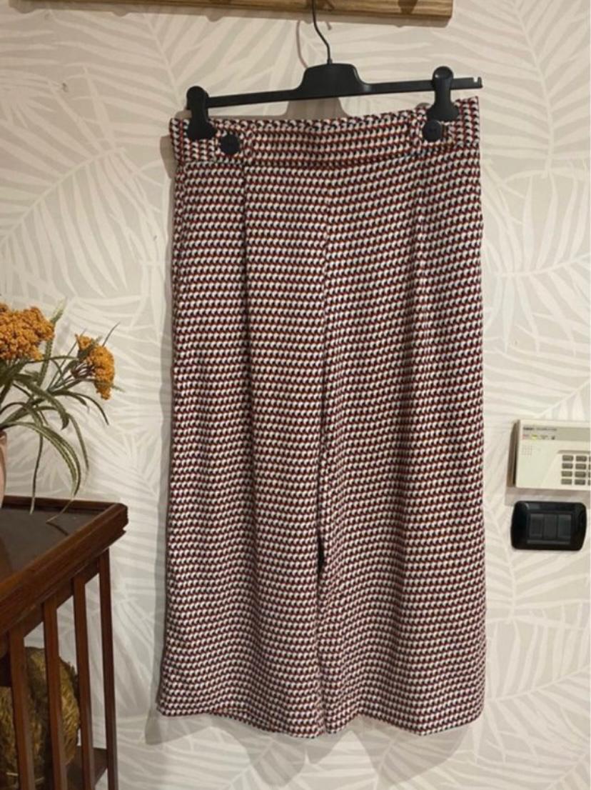 Front view of printed trousers with buttons on the waistband.