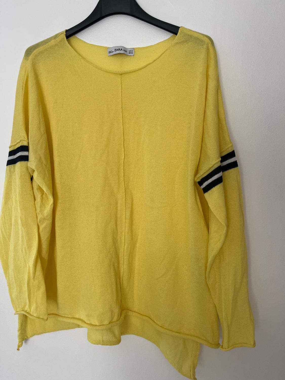 Front view of a yellow jumper with black stripes on the sleeves and a crew neck.