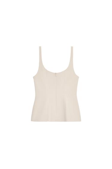 Front view of a fitted beige top with a square neckline, straps, and a peplum hem. Concealed zip fastening at the back.
