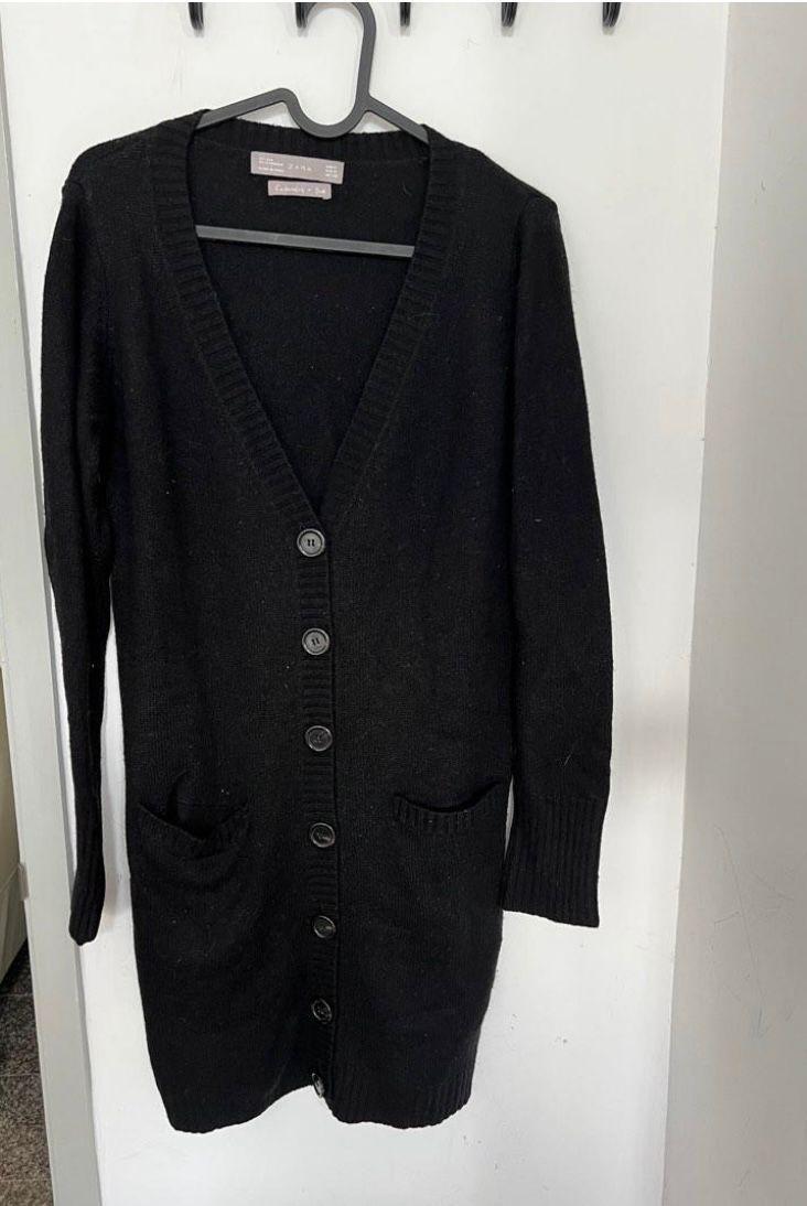 Front view of a black cardigan with buttons and side pockets.