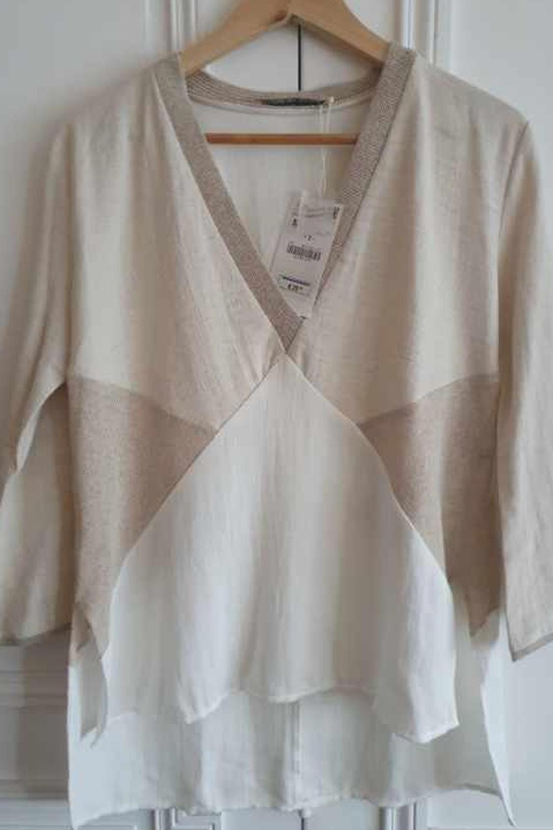 Front view of beige blouse with V-neck and layered design.
