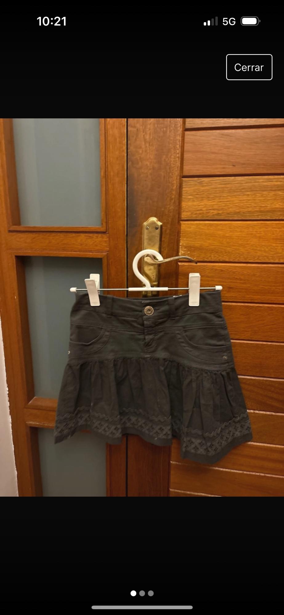 Front view of a black skirt with embroidered details and side pockets.