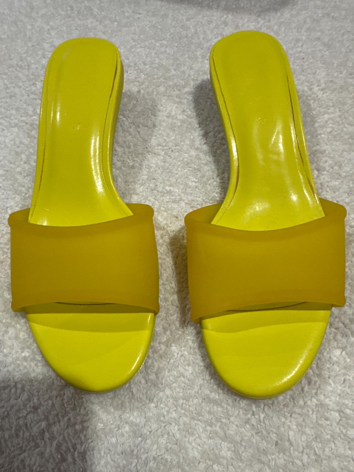 Front view of yellow sandals with a wide upper strap.
