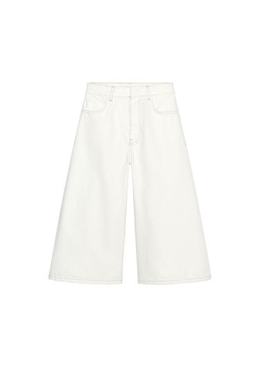 Front view of white flared trousers with front pockets.