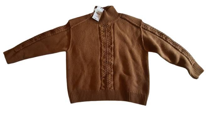 Brown chunky knit jumper with a high neck and cable-knit design on the front and sleeves. Visible hang tag on the collar.