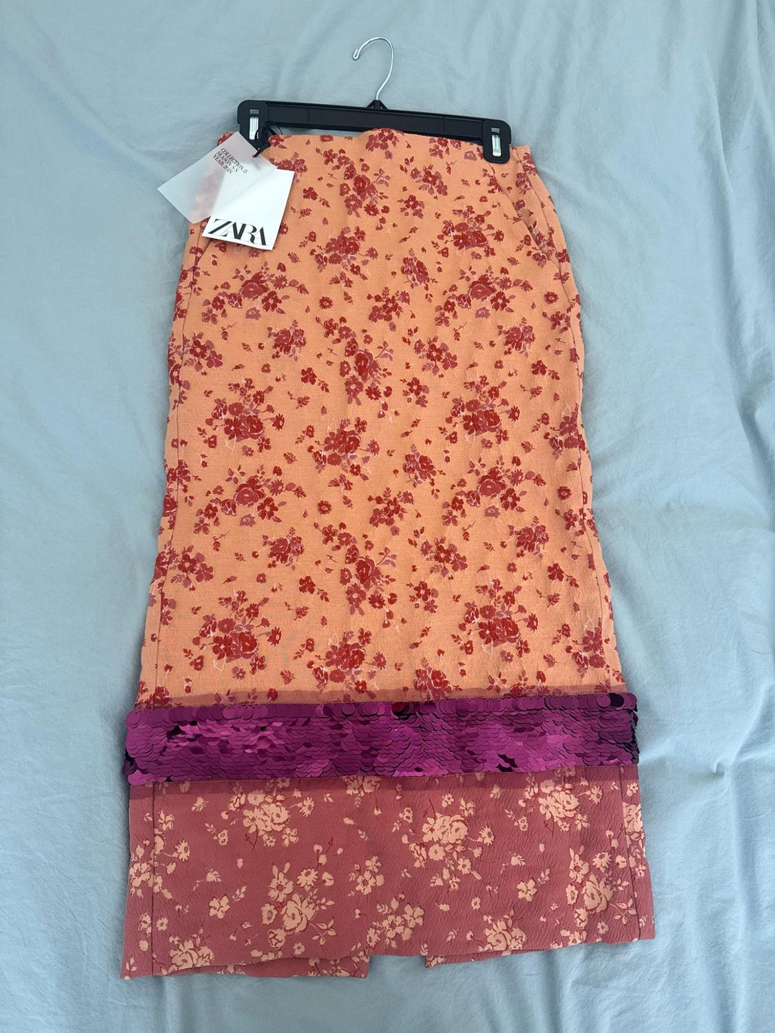 Floral skirt with a purple sequin band on blue fabric. Labels with the text ZARA and COLLECTION IS SEASON SS YEAR 2021.