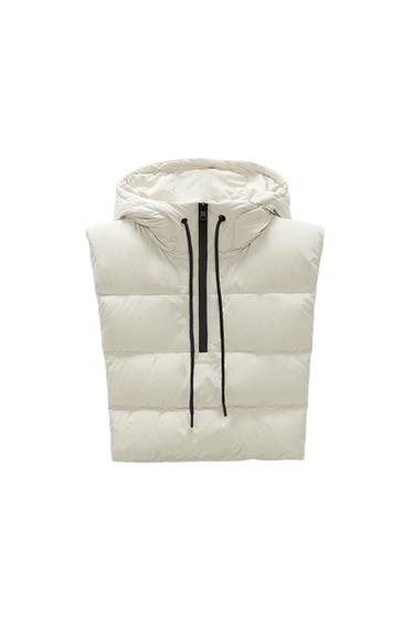 Front view of a white padded gilet with a hood and a black zip fastening.