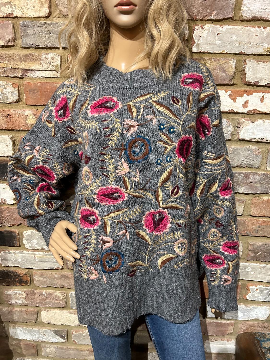 Grey sweater set with floral embroidery in pink and blue, crew neck, long sleeves, over blue jeans.