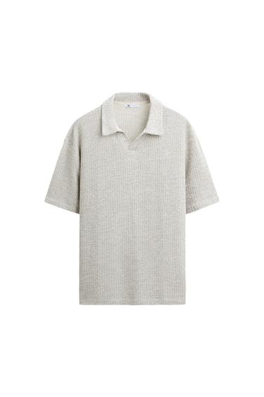 Light grey knitted shirt with an open collar and short sleeves on a white background. Label visible at the neck.