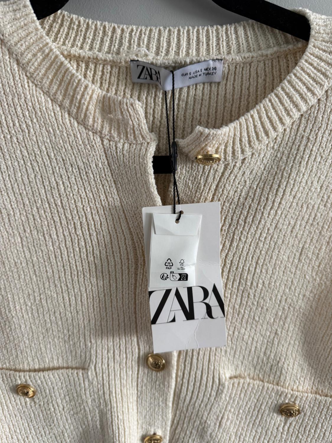 Beige knit jacket with gold buttons and a hanging Zara tag. Inside tag: "EUR S USA 4 MEX 26 MADE IN TURKEY".