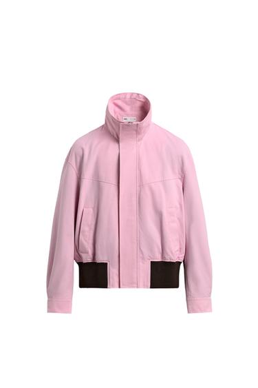 Front view of a pink jacket with a high neck, concealed fastening and side pockets. Featuring contrasting elasticated waist detail.