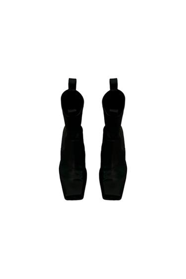 Black square-toe boots viewed from above on a white background.