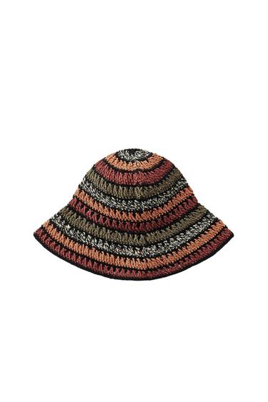 Crochet bucket hat with stripes in shades of brown, orange, olive green, white and black against a white background.