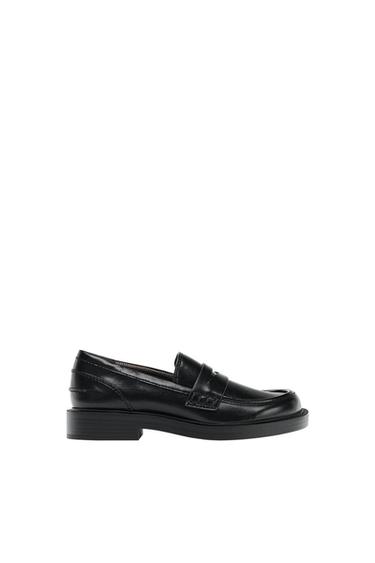 Black loafer shoe with a thick sole, stitching and saddle detail, seen in profile against a white background.