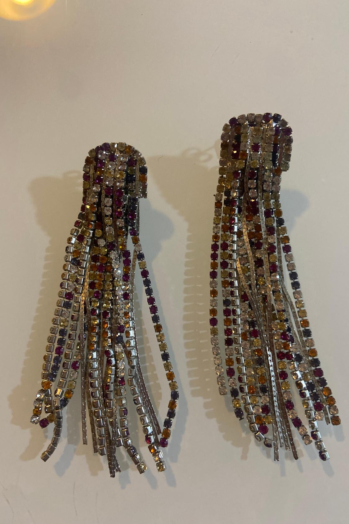 Pair of earrings with dangling multi-coloured crystal strips on a white background.