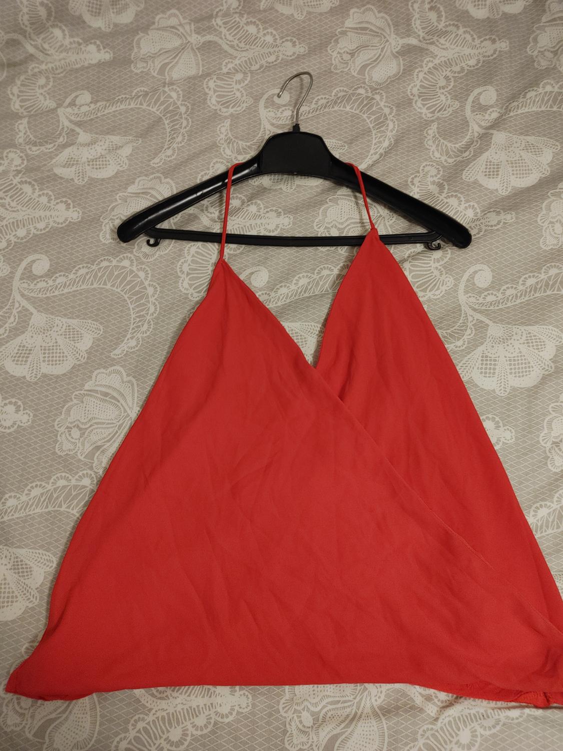 Front view of red top with thin straps and V-neck.