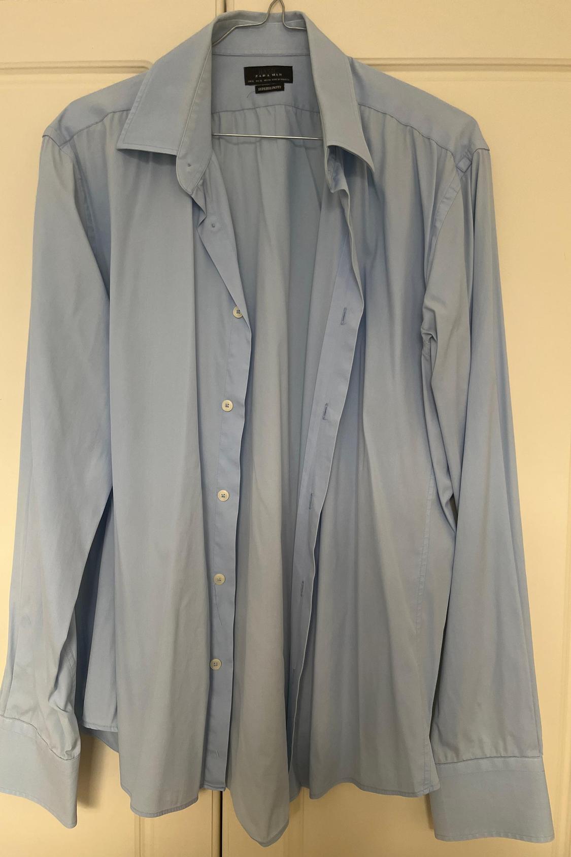Front view of a light blue shirt with buttons and a classic collar.
