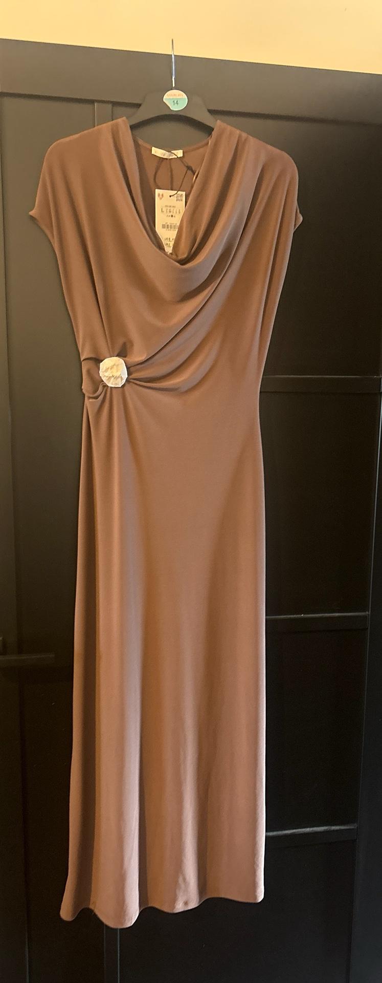 Brown sleeveless maxi dress with a cowl neck and a white flower on the waistband, hanging on a black door. Text: 14.