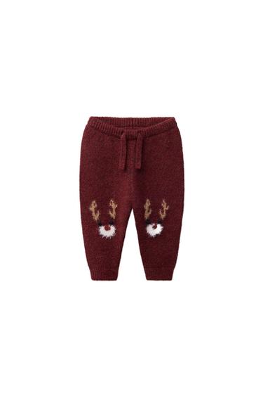 Front view of maroon jogger trousers with elasticated waistband, front drawstrings and reindeer embroidery on legs. Cuffed hem.