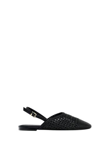Side view of a black sandal with a braided design and an adjustable strap.