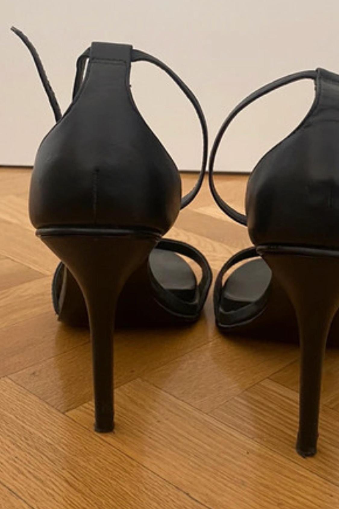 Rear view of black heels with thin straps.