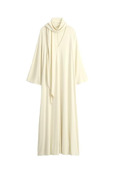 Front view of a cream-colored maxi dress with a V-neck and built-in scarf.