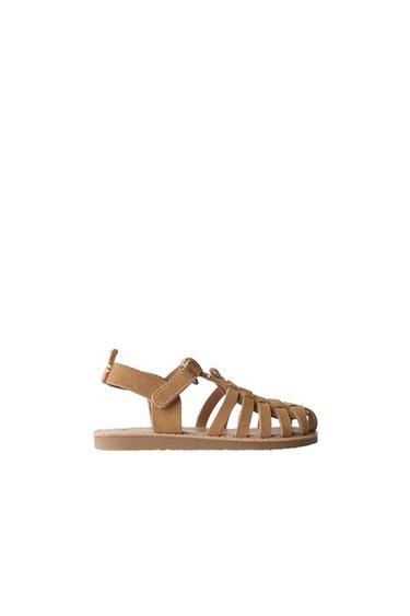 Side view of brown sandal with multiple straps and Velcro fastening.