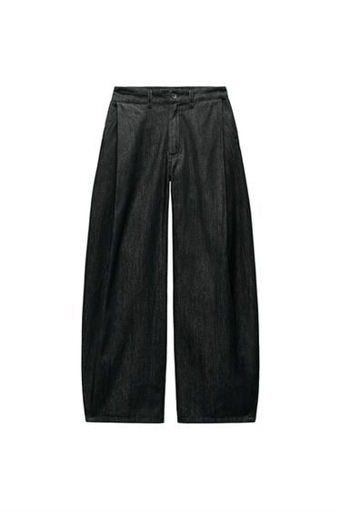 Front view of black wide-leg trousers with pleats and side pockets.