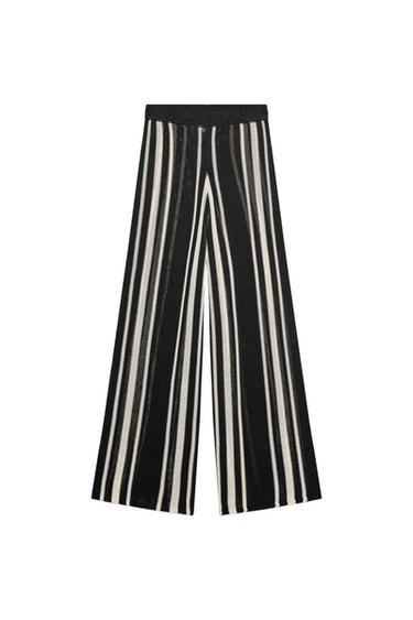 Front view of black pants with black and white vertical stripes, straight cut.