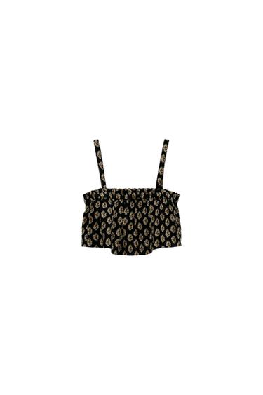Front view of a black camisole top with a beige floral print.