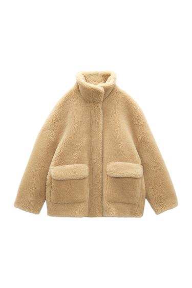 Front view of a beige jacket with front pockets and a high neck.