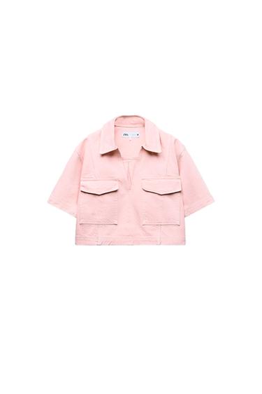 Light pink short-sleeved shirt with a lapel collar, V-neckline, and flap pockets on a white background. Label with ZARA text.