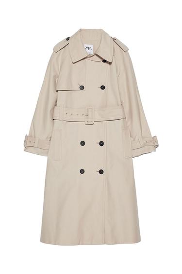 Beige trench coat with a double-breasted black button fastening, adjustable belt and lapels. Visible label with the text "ZARA" on the inside of the neck.