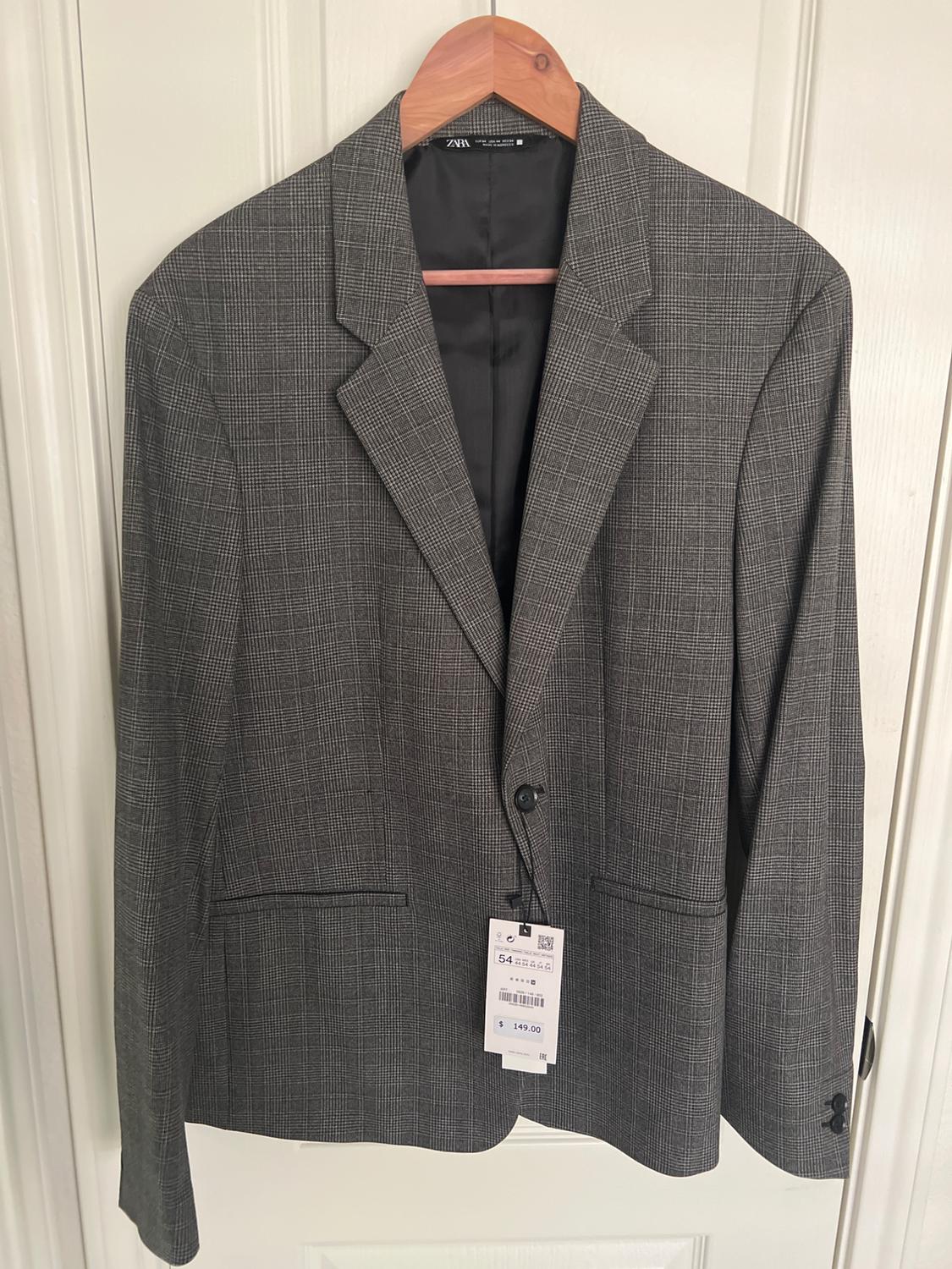 Gray plaid jacket hanging on a wooden hanger, with a visible tag indicating size 54 and a price of $149.00.