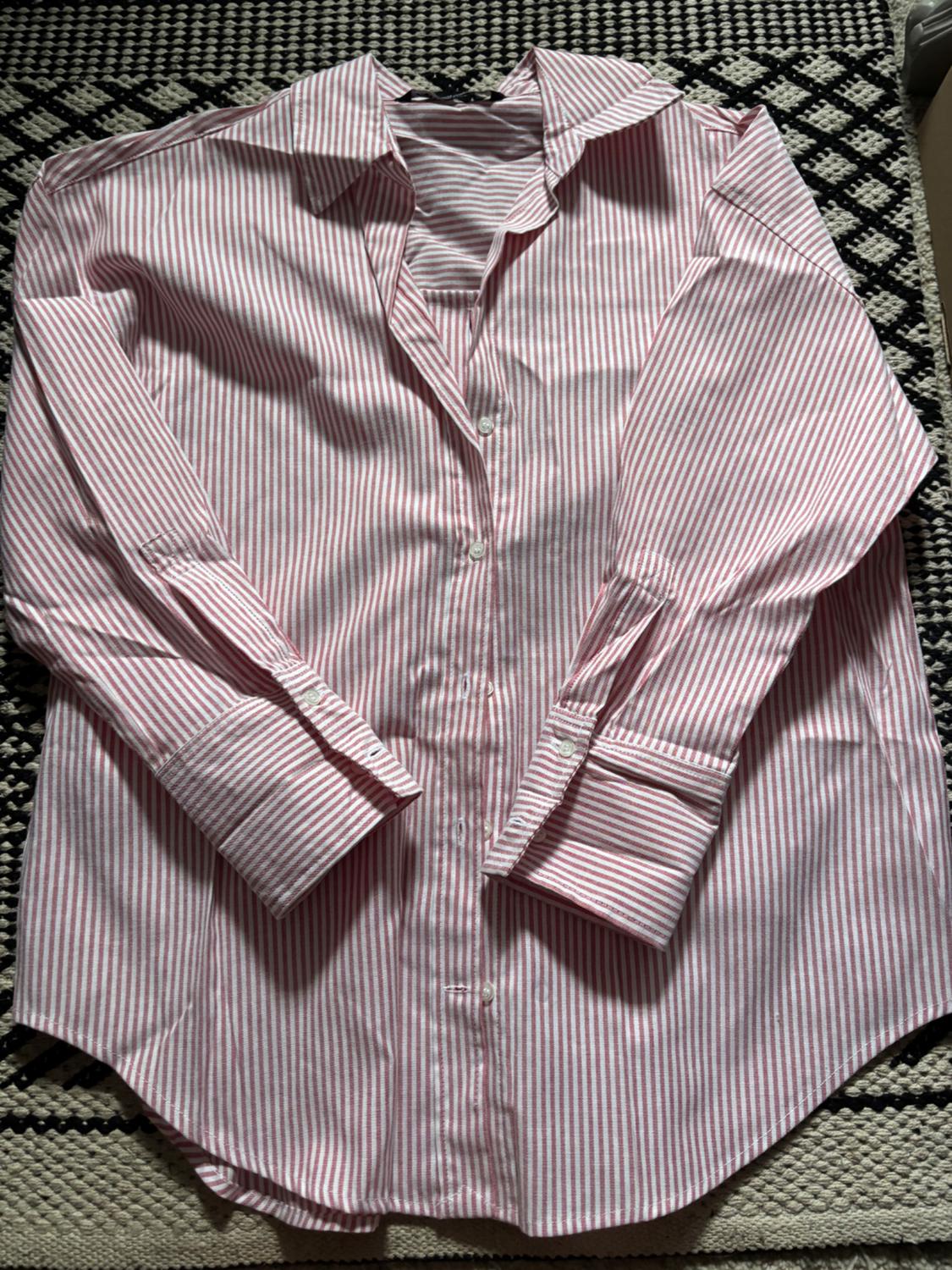 Front view of a red and white striped shirt with a classic collar and long sleeves.