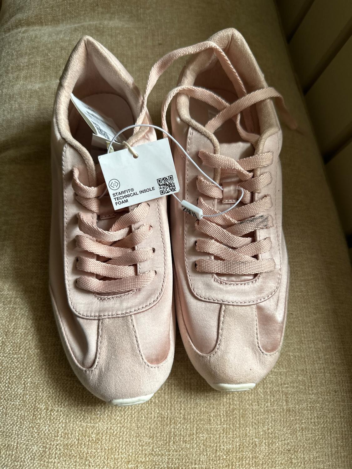 Pink trainers with laces on beige fabric. Label with text: STARFIT® TECHNICAL INSOLE FOAM and ZARA.