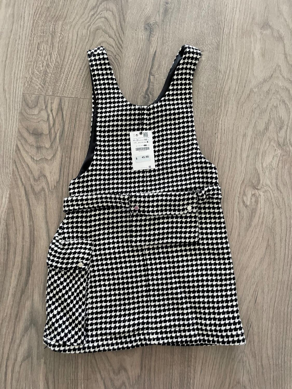 Sleeveless black and white print dress on a wooden floor. Visible tag with price of 45.90.