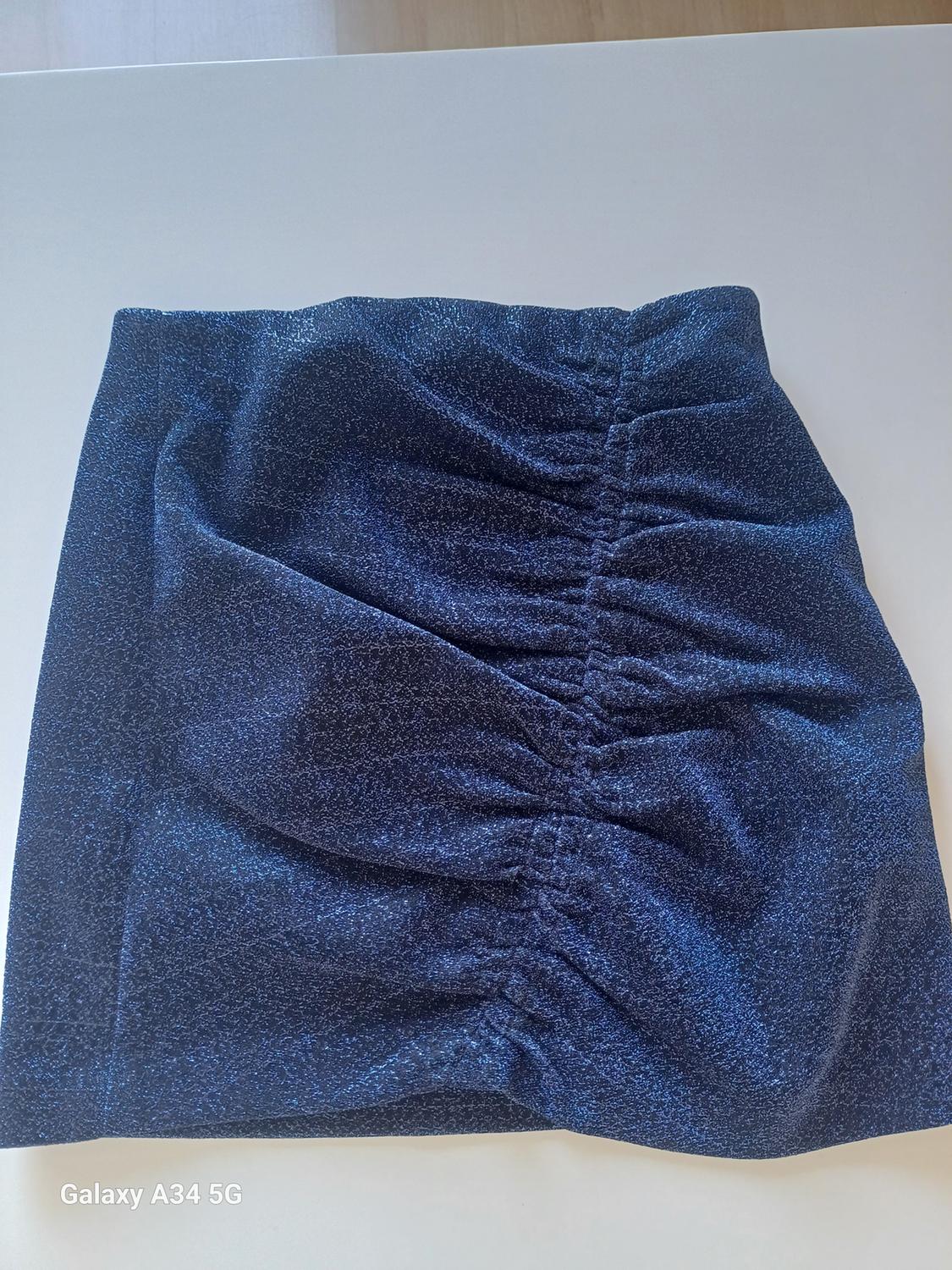 Front view of a blue skirt with central gathering.