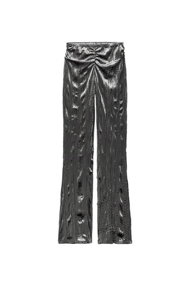 Front view of silver pants with wrinkled texture and elastic waistband.