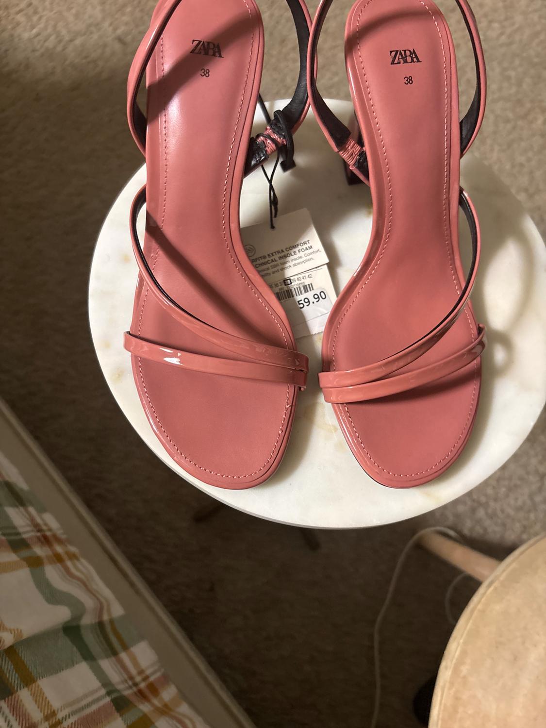 Pink low-heeled sandals with thin straps, ZARA brand, size 38, on white table. Price tag of $59.90 visible.