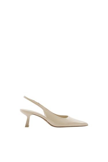 Side view of a beige low-heeled shoe with a pointed toe.