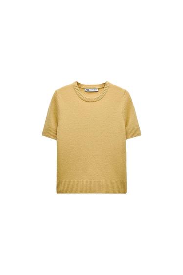 Yellow short-sleeved sweater with a crew neck and soft texture. Visible tag on the inside of the collar. White background.