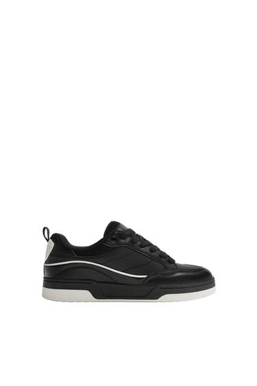 Side view of a black sports trainer with a white sole, white details, and black laces.