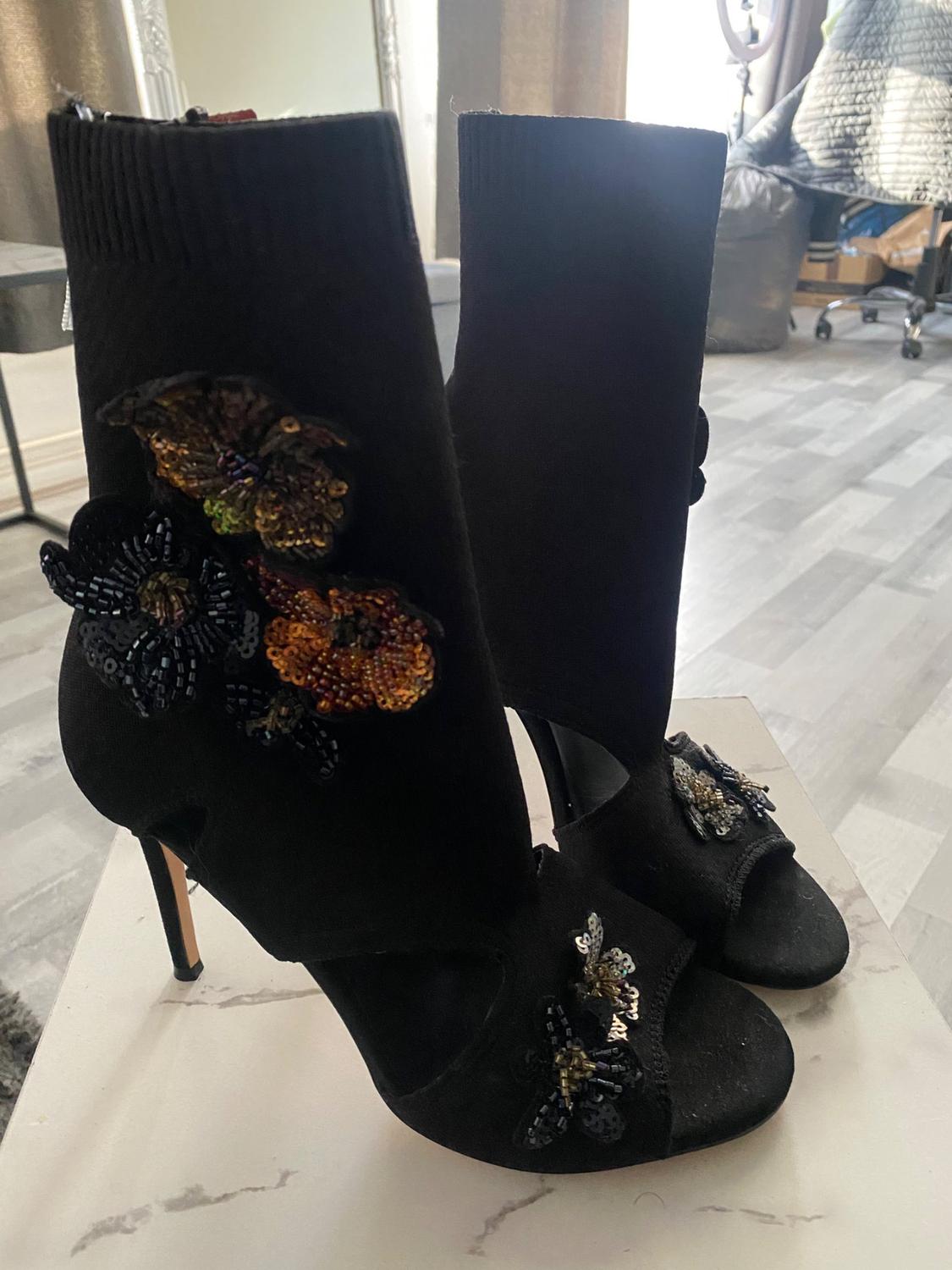 Black high-heeled ankle boots with embroidered butterfly details on the upper and front.
