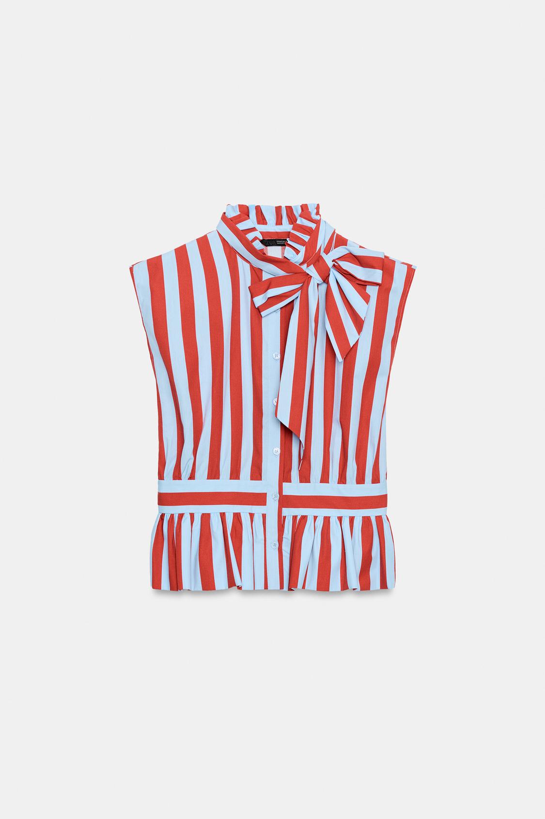 Front view of a red and white striped sleeveless blouse, with a high neck and tie, button fastening, and ruffles at the hem.